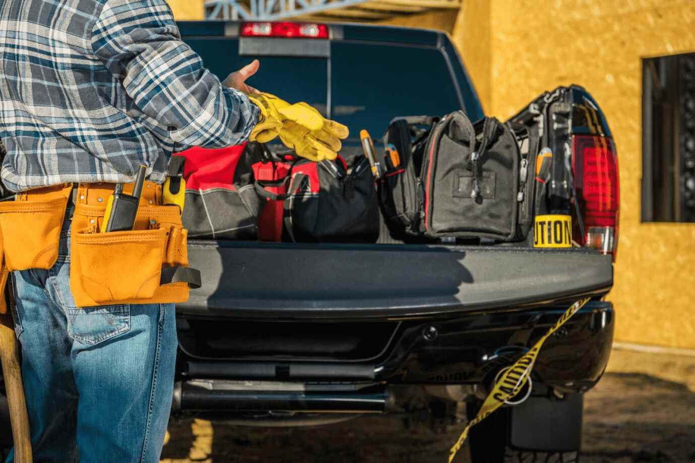 contractor putting on gloves before grabbing tools from truck bed