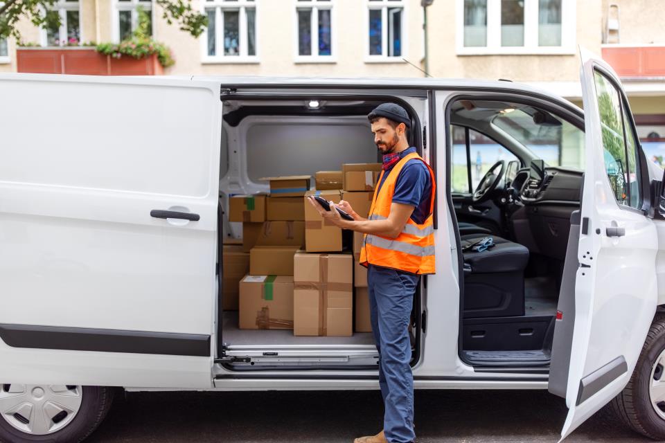 a delivery driver checking his tablet before making a delivery