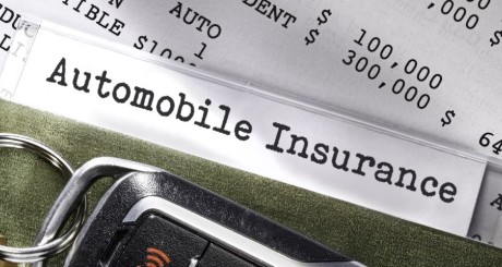 Una póliza de seguro de auto con una llave de un carro. | ¿Puedo Cambiar de Compañía de Seguros de Auto con la Póliza a Mitad de Plazo?
