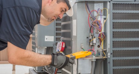 HVAC male technician working on an air conditioning unit