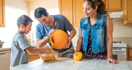 family carving a pumpkin
