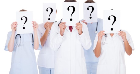cinco médicos sosteniendo signos de interrogación sobre sus caras