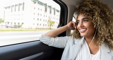 a smiling woman in the back of an Uber