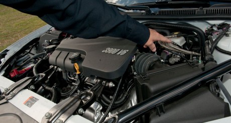 mechanic inspecting under car hood