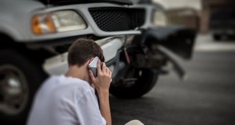 a man talking on his cell phone after a vehicle accident