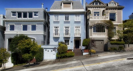 three large houses sitting on a hill