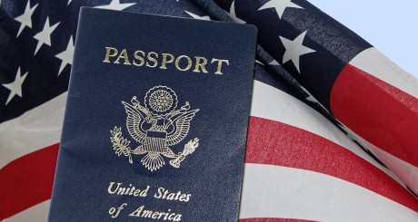 a US passport in front of a waving American flag