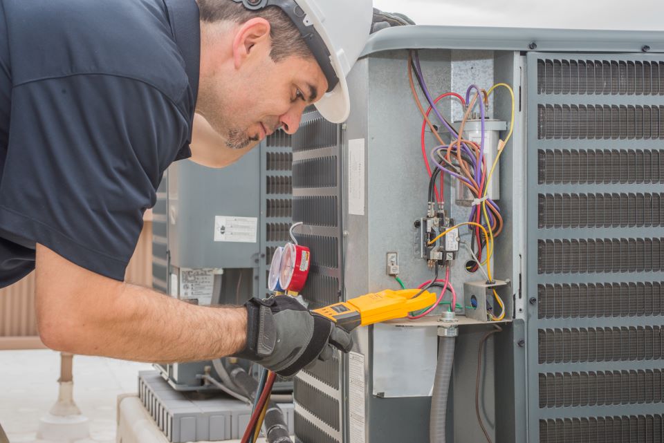 HVAC male technician working on an air conditioning unit