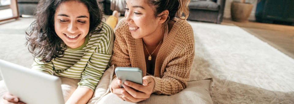 female-roommates-watching-tablet