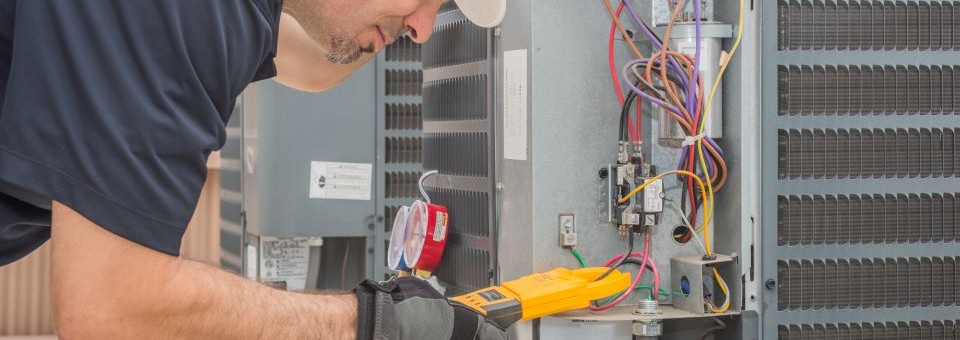 HVAC male technician working on air conditioning unit HVAC male technician working on an air conditioning unit