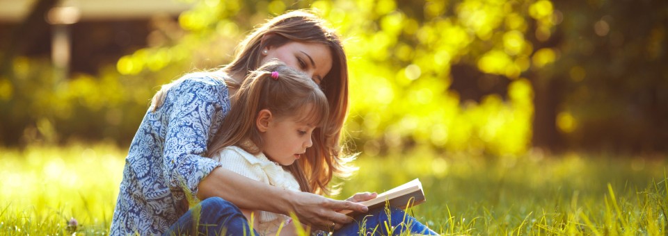 Mom and Daughter Reading in a Field mom-reading-to-daughter-outside